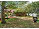 Backyard with brick pathway leading from home to lake with mature landscaping and grass lawn at 17301 Estes Rd, Lutz, FL 33548
