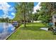 Lakeside backyard with lawn down to the water with dock and mature trees at 17301 Estes Rd, Lutz, FL 33548