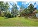 Spacious backyard featuring mature trees, landscaping, and access to the lake, with gazebo at 17301 Estes Rd, Lutz, FL 33548