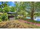 Lakeside backyard with brick path, gazebo, fire pit, and shed access at 17301 Estes Rd, Lutz, FL 33548