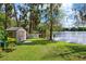 Backyard shed and lawn along the lake, a perfect storage and relaxation area at 17301 Estes Rd, Lutz, FL 33548