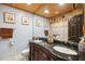 Bathroom featuring granite countertop vanity, dual sinks, rustic wood accents, and decorative lighting at 17301 Estes Rd, Lutz, FL 33548