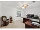 Bright bedroom with neutral tones, ceiling fan, a large window, and a vintage chair at 17301 Estes Rd, Lutz, FL 33548