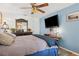 Cozy bedroom with blue accent wall, plush bedding, and ceiling fan with lighting at 17301 Estes Rd, Lutz, FL 33548