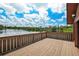 A large wooden deck with railing offers scenic lake views, a perfect spot for entertaining or relaxation at 17301 Estes Rd, Lutz, FL 33548