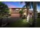 Exterior home showcasing an attached garage, manicured lawn, and artistic yard decor at twilight at 17301 Estes Rd, Lutz, FL 33548