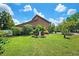 Charming brown home featuring a well-manicured lawn and lush landscaping with a decorative statue in the front yard at 17301 Estes Rd, Lutz, FL 33548