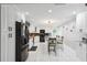 Modern kitchen with marble tile floors, black stainless appliances, updated cabinetry, and dining at kitchen island at 17301 Estes Rd, Lutz, FL 33548