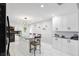 Renovated kitchen with white cabinets, stainless appliances, breakfast bar with seating, and modern lighting at 17301 Estes Rd, Lutz, FL 33548
