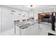 White kitchen offering stone countertops, island seating and a decorative lighting fixture at 17301 Estes Rd, Lutz, FL 33548