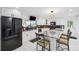 Bright modern kitchen with black appliances, white cabinets, breakfast bar, and a view of the yard at 17301 Estes Rd, Lutz, FL 33548