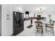 Bright kitchen featuring black appliances, white cabinets, stylish lighting, and breakfast bar with seating at 17301 Estes Rd, Lutz, FL 33548