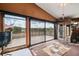 Bright living room featuring lake views, large windows, wood paneling, and an outdoor deck at 17301 Estes Rd, Lutz, FL 33548