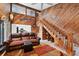 A living room featuring a wooden staircase, comfortable leather furniture, and an open view into the kitchen at 17301 Estes Rd, Lutz, FL 33548