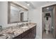 Bathroom with granite countertop, large mirror, single sink vanity, and access to a nearby shower and toilet room at 19700 Gulf Blvd # 403, Indian Shores, FL 33785