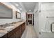 Bathroom with dual sinks, granite counters, tile floors, and a walk in shower at 19700 Gulf Blvd # 403, Indian Shores, FL 33785