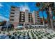 A ground level exterior view of the 700 West condo building on a sunny day with lush landscaping at 19700 Gulf Blvd # 403, Indian Shores, FL 33785