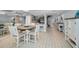 Open-concept dining area with a round table, tile floors, and views into the modern kitchen at 19700 Gulf Blvd # 403, Indian Shores, FL 33785