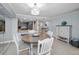 Bright dining area with a round table, stylish chandelier, and views into the modern kitchen at 19700 Gulf Blvd # 403, Indian Shores, FL 33785