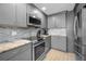 Updated kitchen with granite countertops, stainless appliances, and sleek gray cabinetry at 19700 Gulf Blvd # 403, Indian Shores, FL 33785