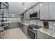 Modern kitchen with stainless steel appliances, granite countertops, and access to the dining area at 19700 Gulf Blvd # 403, Indian Shores, FL 33785