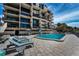 Beautiful building featuring private balconies and a blue pool with lounge chairs at 19700 Gulf Blvd # 403, Indian Shores, FL 33785
