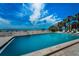 Beautiful outdoor pool with clear blue water surrounded by lush greenery and palm trees overlooking the ocean beach at 19700 Gulf Blvd # 403, Indian Shores, FL 33785