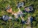 Aerial view of luxury homes with mature trees, long driveways, and one with a screened in pool at 20 Willowwood Ln, Oldsmar, FL 34677