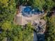 Aerial view showcasing the home's roof, screened in pool area, and surrounding lush greenery at 20 Willowwood Ln, Oldsmar, FL 34677
