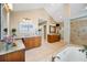 Bright bathroom featuring double vanities, soaking tub, and a glass enclosed shower at 20 Willowwood Ln, Oldsmar, FL 34677