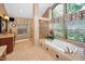Bright bathroom featuring a soaking tub, walk-in shower, and vanity with double sinks at 20 Willowwood Ln, Oldsmar, FL 34677
