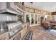 Covered outdoor kitchen with stainless steel grill and brick flooring at 20 Willowwood Ln, Oldsmar, FL 34677