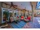 Relaxing covered patio with comfortable seating, ceiling fans, and brick flooring at 20 Willowwood Ln, Oldsmar, FL 34677
