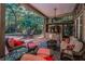 Covered patio with flat screen TV, comfortable seating and a view of the lush backyard at 20 Willowwood Ln, Oldsmar, FL 34677