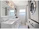 Bathroom featuring a double vanity, large mirror, and a combination washer/dryer for added convenience at 2001 E Idlewild Ave, Tampa, FL 33610