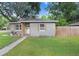Cozy single-story home with decorative wood shutters and a lush green lawn at 2001 E Idlewild Ave, Tampa, FL 33610