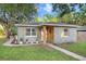 Charming single-story home with a well-maintained lawn and decorative shutters at 2001 E Idlewild Ave, Tampa, FL 33610