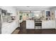 Open-concept kitchen with stainless steel appliances, white cabinets, and views into the living room at 2001 E Idlewild Ave, Tampa, FL 33610