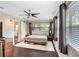 Spacious bedroom featuring a ceiling fan, dark wood floors, lots of light, and access to the en-suite bathroom at 2001 E Idlewild Ave, Tampa, FL 33610