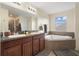 Bathroom featuring dual sinks, vanity, bathtub, and shower at 21046 Passive Porch Dr, Land O Lakes, FL 34637