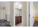 Hallway view into shared bathroom with dual sinks and dark wood cabinets at 21046 Passive Porch Dr, Land O Lakes, FL 34637