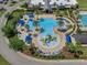 Aerial view of community pool with zero entry, waterslides, and covered lounge areas at 21046 Passive Porch Dr, Land O Lakes, FL 34637