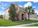 Charming two-story home featuring a stone-accented entrance, lush landscaping, and a well-manicured lawn at 21046 Passive Porch Dr, Land O Lakes, FL 34637