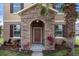 Inviting front entrance with a stone archway and colorful landscaping, complete with a tasteful brown door and shutters at 21046 Passive Porch Dr, Land O Lakes, FL 34637