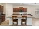 Open kitchen with island, granite countertops, and wood cabinetry at 21046 Passive Porch Dr, Land O Lakes, FL 34637