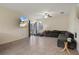 Inviting living room featuring neutral tones, tile flooring, a large sectional sofa, and a ceiling fan at 21046 Passive Porch Dr, Land O Lakes, FL 34637