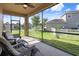 Relaxing screened porch with chairs, offering a view of the community at 21046 Passive Porch Dr, Land O Lakes, FL 34637