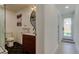 Stylish bathroom showcases a round mirror, modern vanity, and black hexagonal floor tiles leading to an exterior door at 2488 Del Rio Way, Dunedin, FL 34698