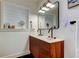 Bright bathroom with a stylish wood vanity, double sinks and accent mirror at 2488 Del Rio Way, Dunedin, FL 34698