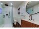 Modern bathroom features a glass enclosed shower, black hardware, and a unique wooden vanity at 2488 Del Rio Way, Dunedin, FL 34698